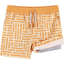 Load image into Gallery viewer, Light orange swim trunks, with an orange and white geometric pattern, against a plain white backdrop. The bottom right leg is flipped up to expose the hem.