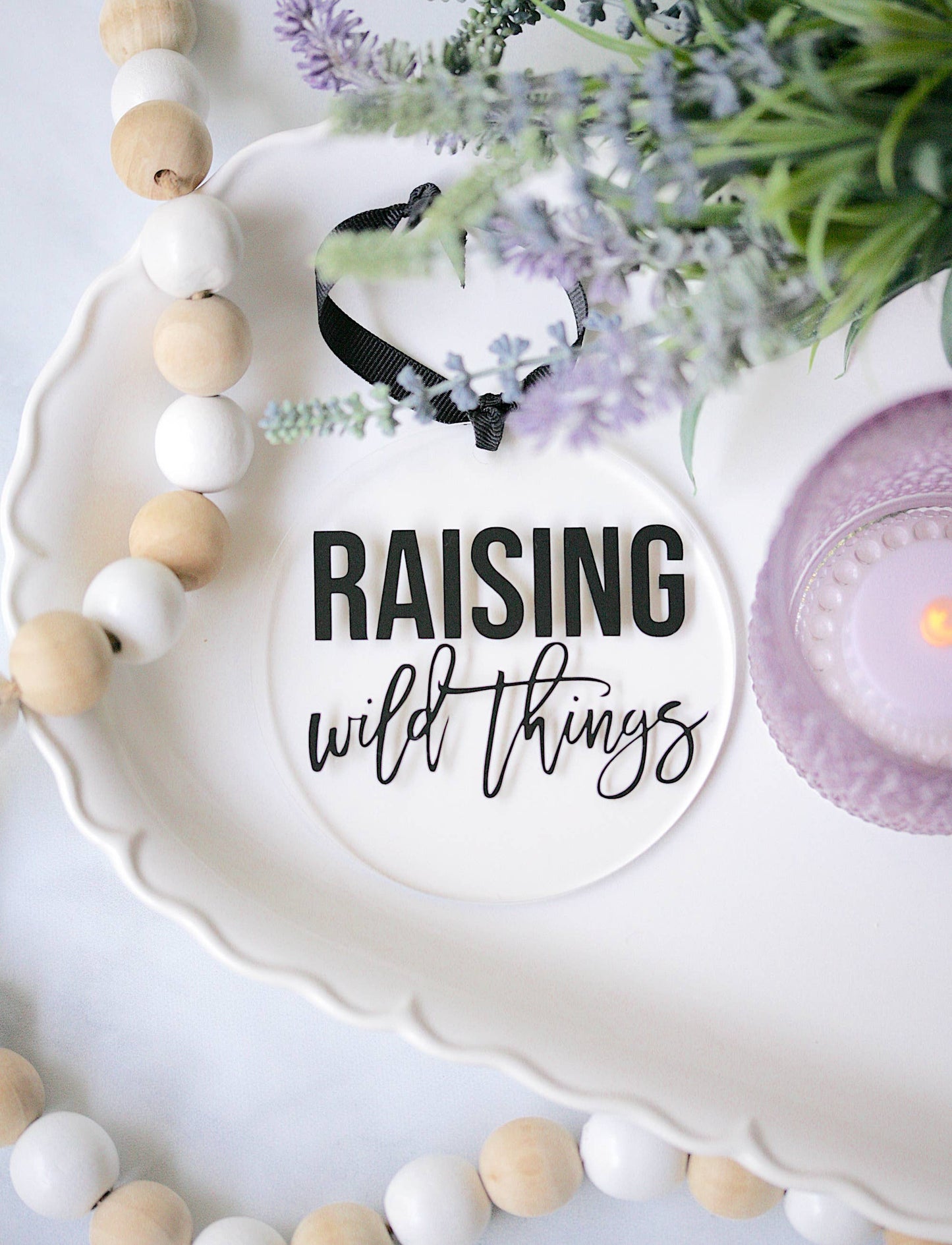 Raising Wild Things acrylic ornament, clear with vinyl detail, hanging from black ribbon