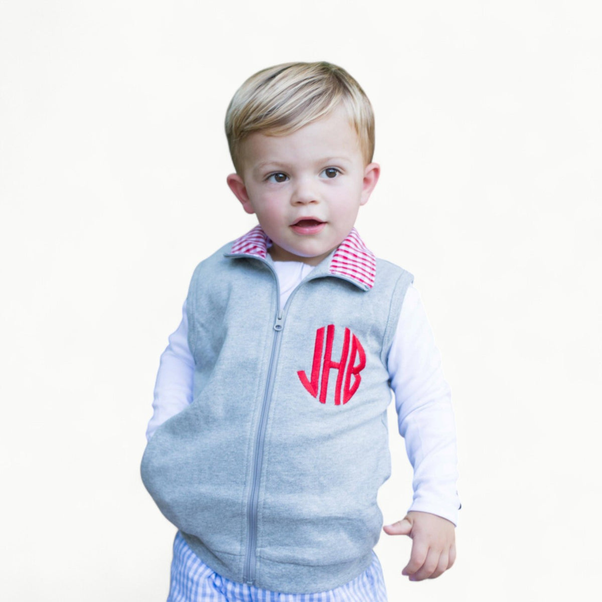 Grey gingham vest with red accent, full zip closure and ribbed sleeves