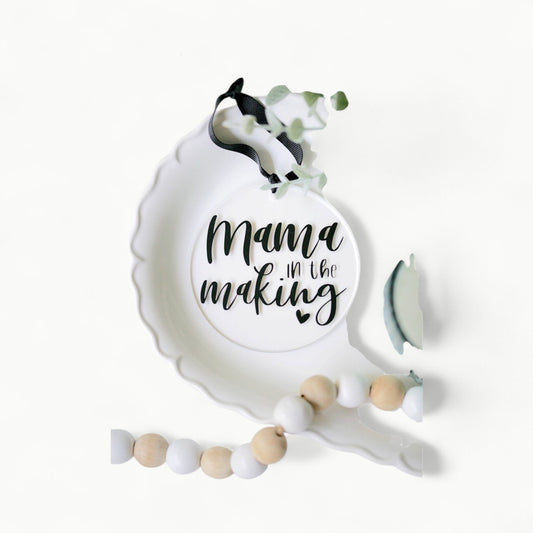 Clear acrylic Mama In The Making ornament with vinyl detail, 4 inch diameter, black ribbon hanger