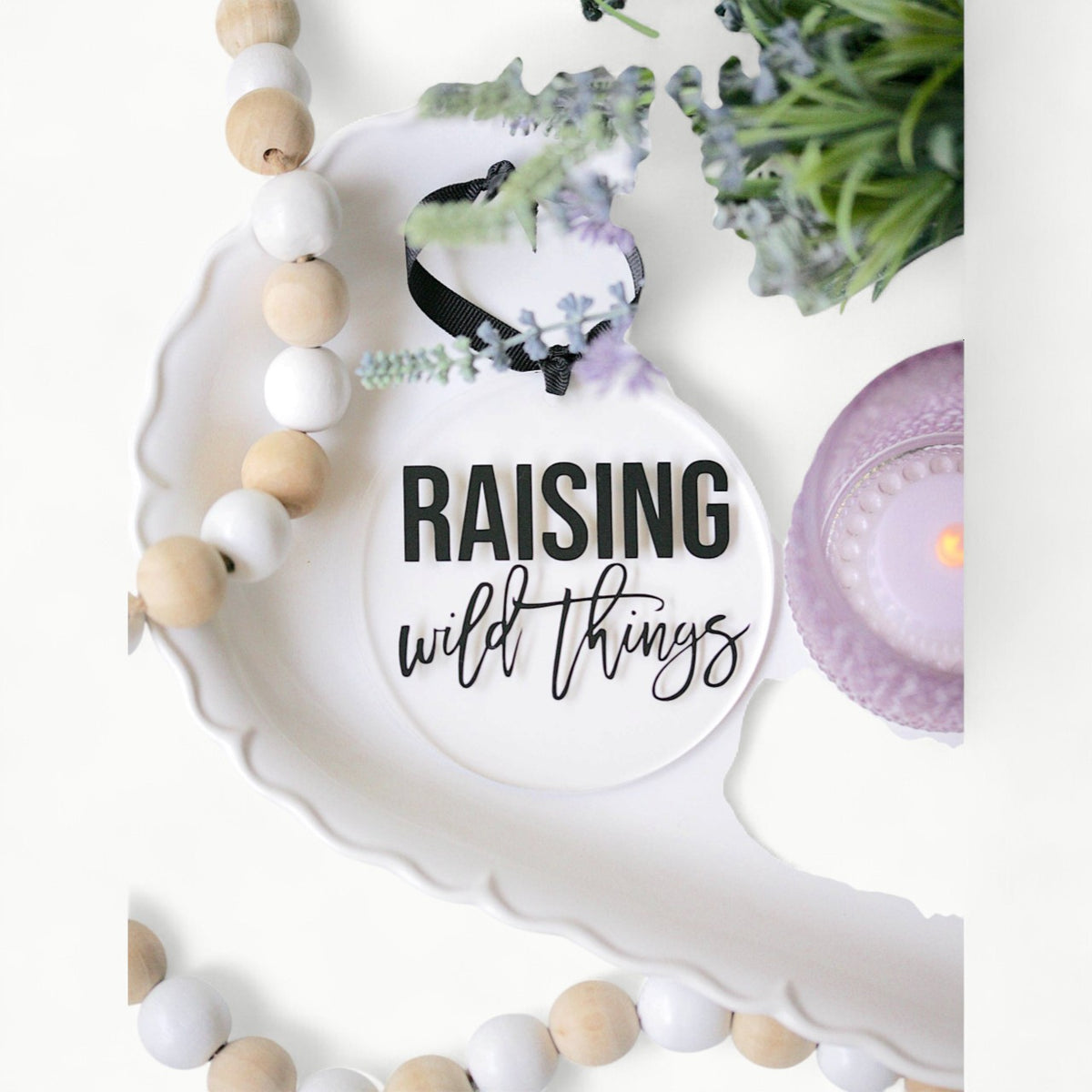 Raising Wild Things acrylic ornament, clear with vinyl detail, hanging from black ribbon