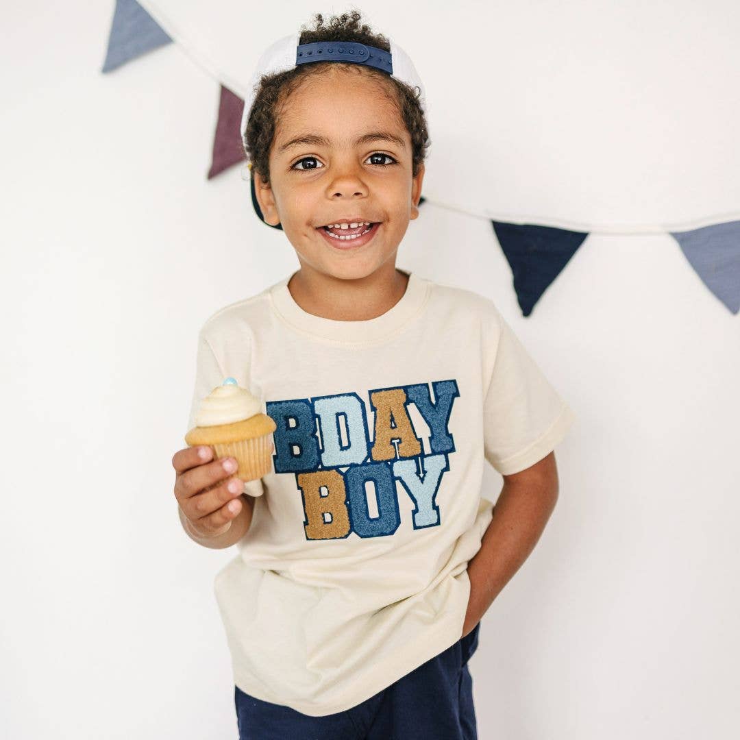 Natural cotton t-shirt with indigo, soft blue, and khaki embroidered patches outlined in navy felt