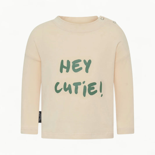 Hey Cutie Tee by Tiny Tribe in cream, featuring centre-front typography and side snap button detailing.