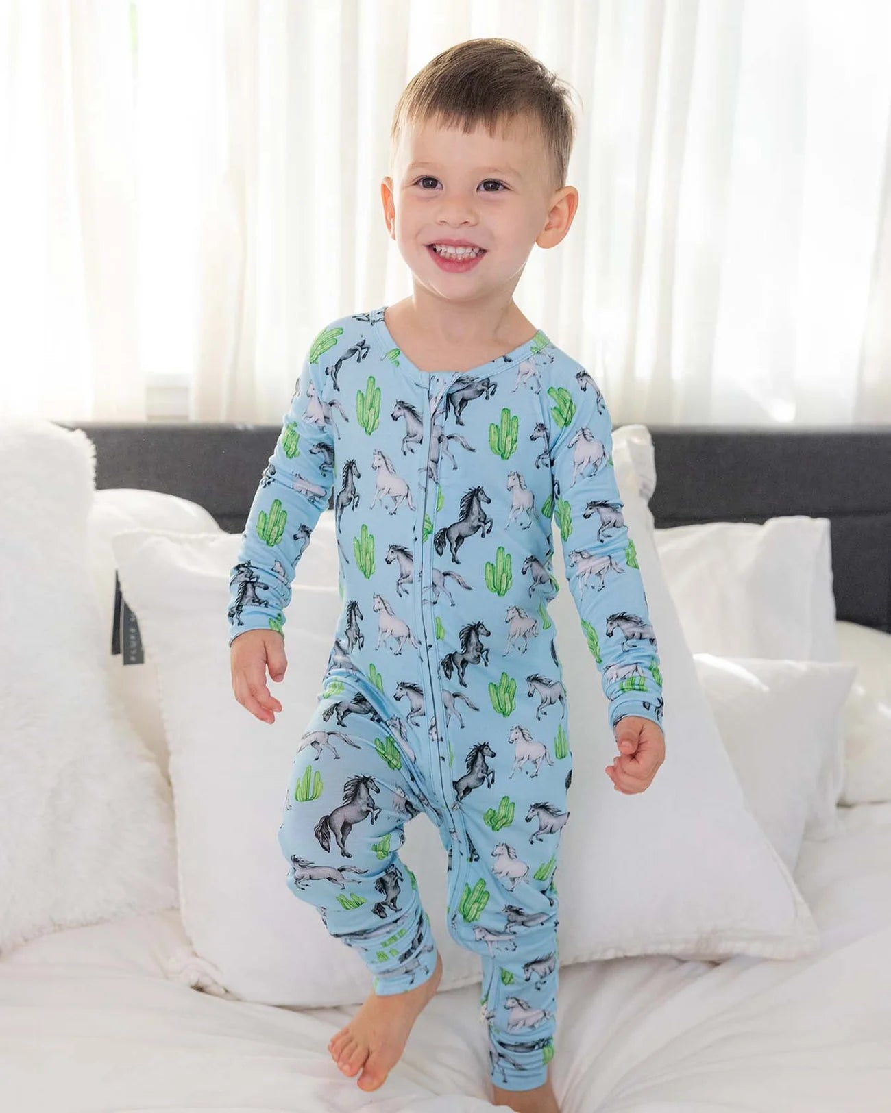 Harrison Poppy Convertible Romper in sky-blue with hand-illustrated horse and cactus print, convertible feet design