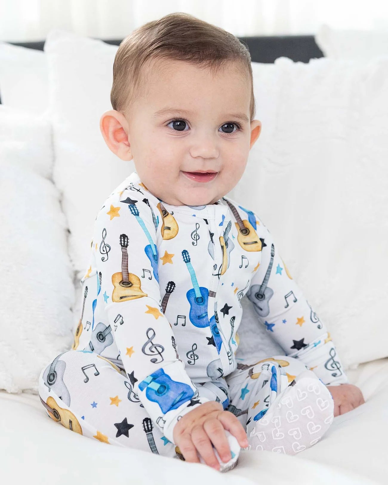 Brad Zippered Footie by Lev Baby in organic bamboo with hand-illustrated acoustic guitars, treble clefs, and stars on blue