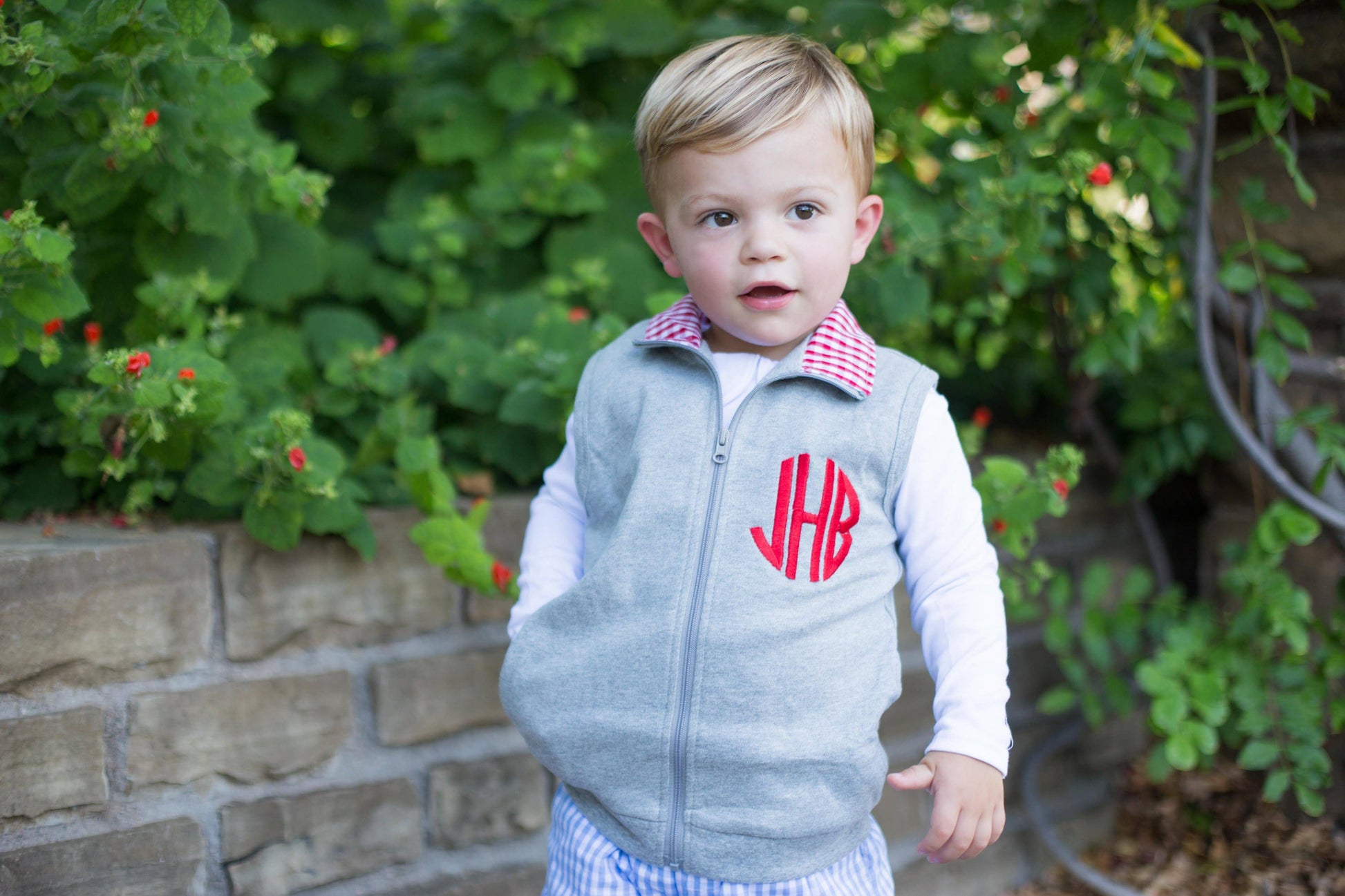Grey gingham vest with red accent, full zip closure and ribbed sleeves