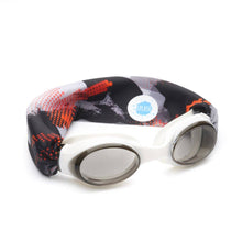 Load image into Gallery viewer, Our dimension swim goggle features our tangle-free, patent-pending strap in a red, grey and black abstract print. Paired with a white frame and lightly tinted grey lenses. One size fits kids to adults. Ages 3+. No more pulled or tangled hair. Fun, fashionable, comfortable. High visibility, anti-fog lenses. Shatter resistant polycarbonate lenses. Hypoallergenic—latex &amp; pvc free. Sensory friendly.
